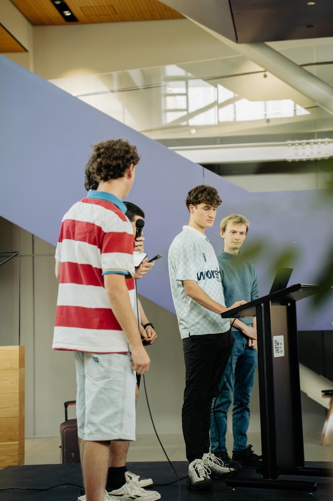 A Young Kiwis in AI team pitching on stage at the SaaSathon in Christchurch